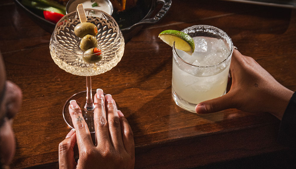 Guests with Dirty martini and other cocktail plus food items at Blue Hound Kitchen