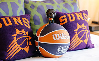 Phoenix Suns pillows + a basketball on a bed