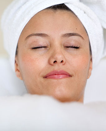 woman relaxing in bathtub with bubbles