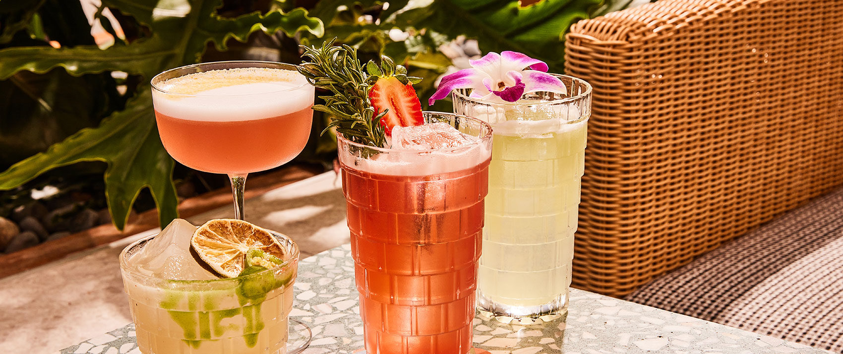 Cocktails on table outside by wicker chair